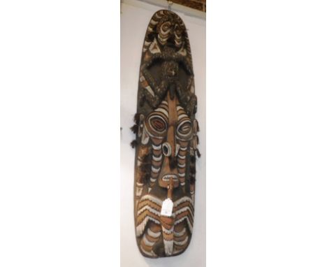 PAPUA NEW GUINEA: A LARGE PAINTED AND CARVED WALL HANGING decorated with a naked man, with cowrie eyes, a similar 'stick figu