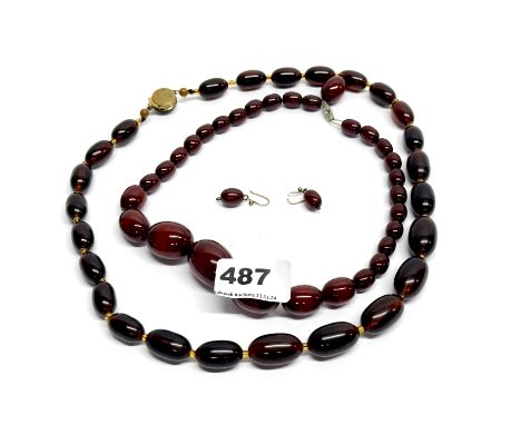 A vintage graduated faux cherry amber necklace, L. 44cm with a pair of matching earrings and a faux brown amber necklace.
