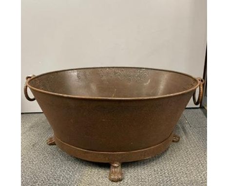 A large iron bath/planter with paw feet, W. 76cm.