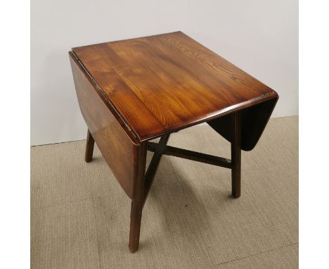 An Ercol drop leaf stained elm dining table, extended 137 x 75 x 72cm.