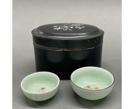 A 19thC mother of pearl decorated tin tea caddy, W. 15cm. With two Chinese porcelain tea bowls.