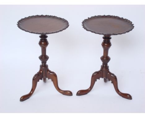 A pair of late 19th Century mahogany wine tables, the circular top with raised scalloped and gadroon carved rim, on turned st