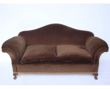 An early 20th Century hump back sofa, with scrolled arms, on shell capped squat cabriole legs and pad feet, with two squat cu