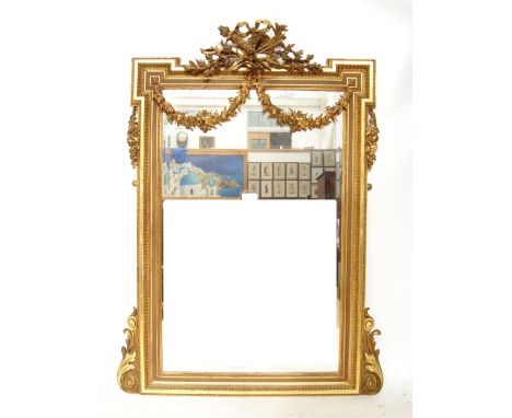 A large 19th Century French gilt gesso carved giltwood wall mirror, the rectangular bevelled plate within a moulded and beade