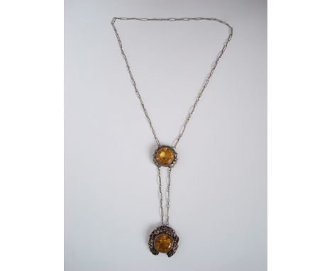 An Arts and Crafts citrine pendant, centred with a circular collet set citrine within a pierced floral wreath surround, suspe