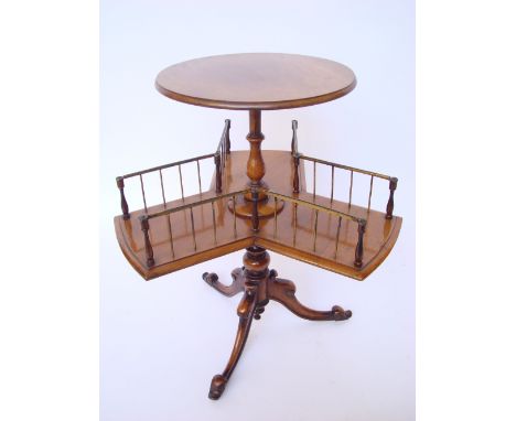 A Victorian walnut revolving two tier book table, the circular top on baluster stem above a revolving gilt brass galleried ca