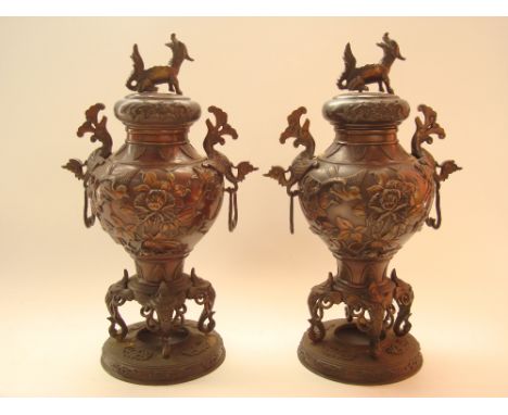 A pair of late 19th Century Japanese bronze vases and covers, of baluster form, the bodies cast in raised relief with birds a