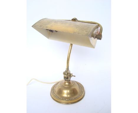 An early 20th Century brass desk lamp, on adjustable supports and loaded circular base. 