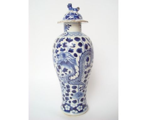 A Chinese blue and white baluster vase and cover, decorated with scrolling dragons amongst foliage, the domed covered with do