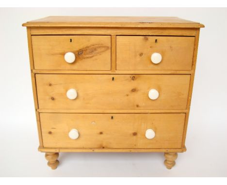 A Victorian pine chest of drawers, with two short and two long drawers, with white ceramic handles, on turned feet.
85 x 46 x
