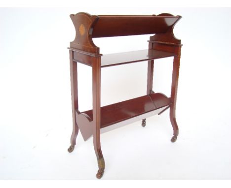 An Edwardian mahogany floor standing two tier book trough, strung and inlaid with paterae, on square supports with out swept 
