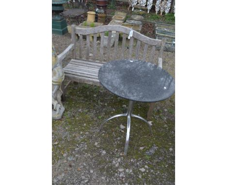 A TEAK SLATTED GARDEN BENCH, width 121cm together a chromed framed circular garden table with a granite top, diameter 70cm 