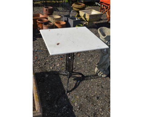 A SQUARE WHITE MARBLE TOPPED GARDEN TABLE on a separate wrought iron stand, 70cm squared x height 75cm 