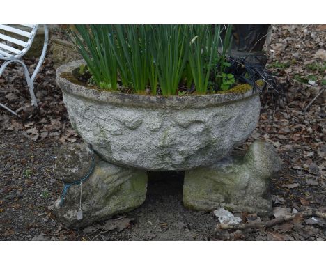 A LARGE CIRCULAR COMPOSITE GARDEN PLANTER with worn decoration to perimeter on separate triple mythical creatures, diameter 7