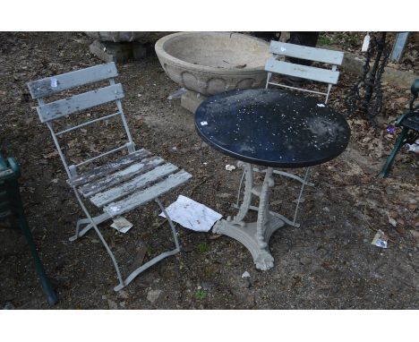 A CIRCUALR SLATE TOPPED GARDEN TABLE on a painted cast iron base, diameter 65cm x height 70cm together with a pair of painted