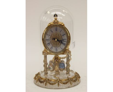 A vintage Franklin Mint German-manufactured glass-dome skeleton clock, ormolu decoration and porcelain and ormolu revolving E
