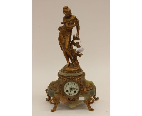 A French style gilt metal and onyx eight day figural mantle clock, the top surmounted by a young gentleman near foliage