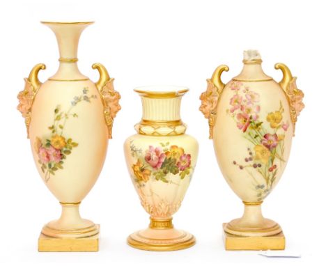 Three Royal Worcester blush ivory vases including a pair of mask moulded twin handled pedestal vases, painted with flowers an