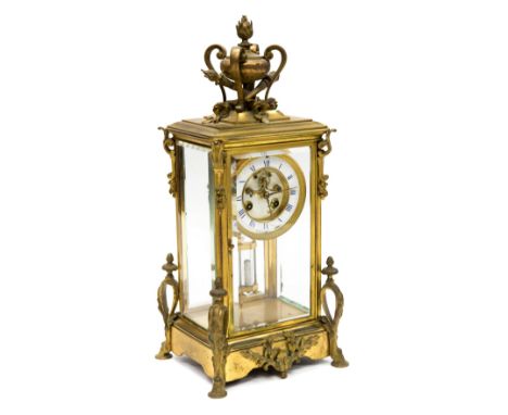 French brass four-glass mantel clock, circa 1890, the upright case with a modelled trophy surmount, scroll applied decoration