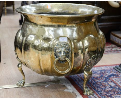 A large brass planter, raised on three paw feet 
