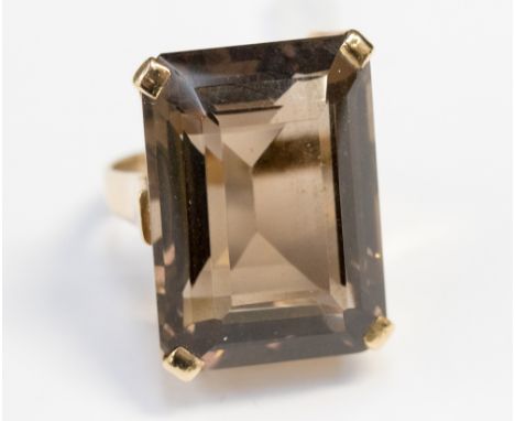 A smokey quartz 9ct gold dress ring, the rectangular step cut stone with truncated corners measuring approximately 25 x 18mm,