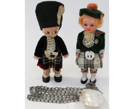 A white metal and Nacre shell perfume bottle suspended on a chain; together with two Kewpie style dolls, dressed in tartan - 