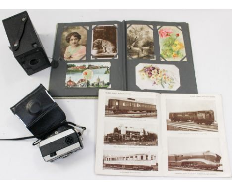 An Edwardian (some later) postcard and photo album with Louis Wain card, an Ensign cased camera 1920/30s and a Kodak Instamat
