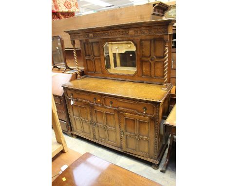 A George V oak mirror-backed sideboard, the upper section with an inset bevelled edge mirror and geometrically moulded surrou