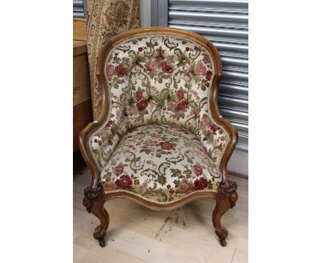 A mid Victorian walnut deep button backed armchair, carved knees and raised on cabriole legs