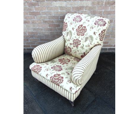 A RE-UPHOLSTERED VICTORIAN ARMCHAIR  on turned supports with ceramic casters