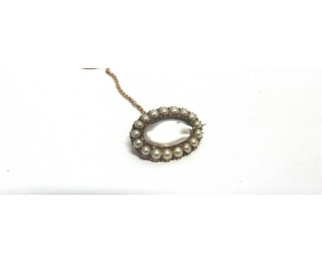 A VICTORIAN SPLIT PEARL LOCKET BROOCH unmarked, the central glazed panel vacant, of oval outline, 2.5cm long, 6.3g gross