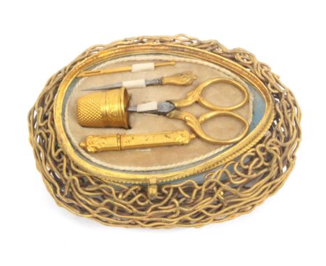 A mid 19th Century French sewing etui for a child or doll, in the form of a blue glass egg in a gilded wire work nest, the hi