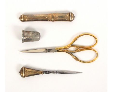 Four sewing tools, comprising a French gold engraved needle case of oval section, 6.5cm, a matching stiletto, an engraved bor