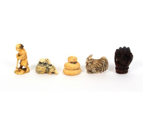 Four netsuke and a figure, comprising a carved wooden netsuke as a hand enclosing a figure, 5cms, a 19th Century Japanese ivo