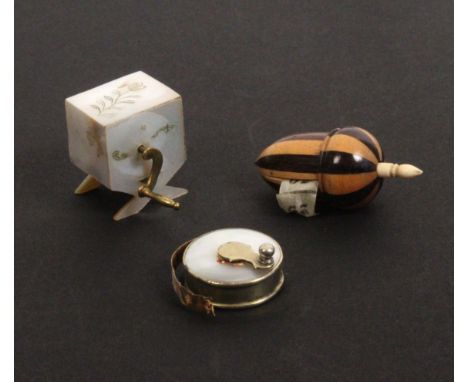 Three tape measures, comprising an acorn form example in alternate light and dark woods, bone spindle, the incomplete tape pr