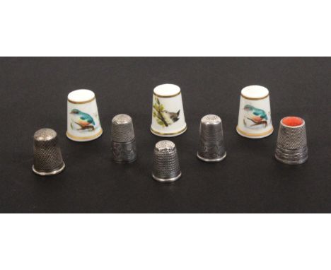 Eight thimbles, comprising two early 19th Century silver examples, both with deep decorated borders divided by a vacant carto