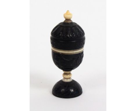 A fine early 19th Century carved coconut and bone thimble case of urn form, with ivory thimble, the case carved with love bir