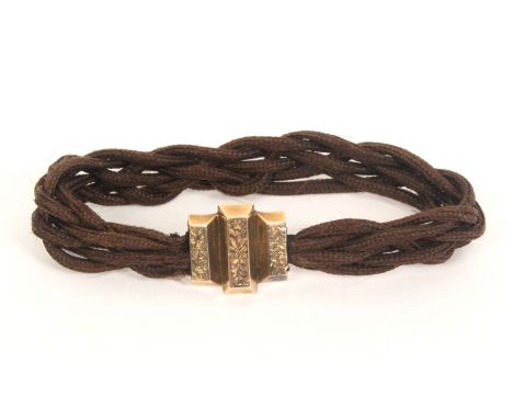 A 19th Century entwined and plaited hair mourning bangle, the floral engraved mount initialled to reverse ‘EG’.&nbsp; &nbsp; 