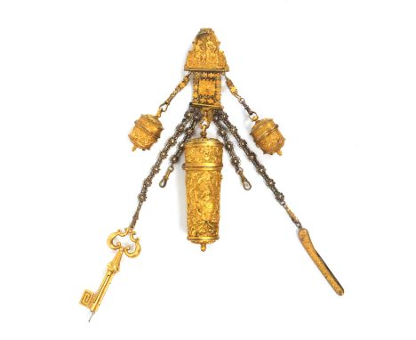 A late 18th Century gilt metal chatelaine and fittings, the scroll border hook mount with classical figures in a garden above