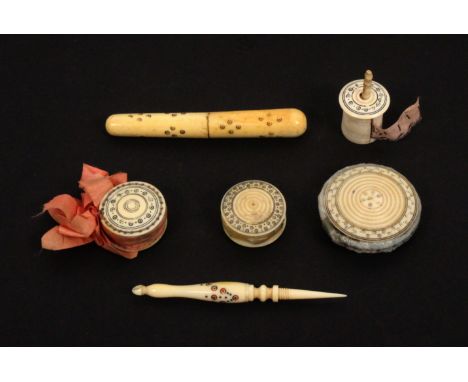 Six 19th Century ivory Madras sewing tools, with burnt circle decoration comprising a cylinder needle case, 8.2cms, three dis