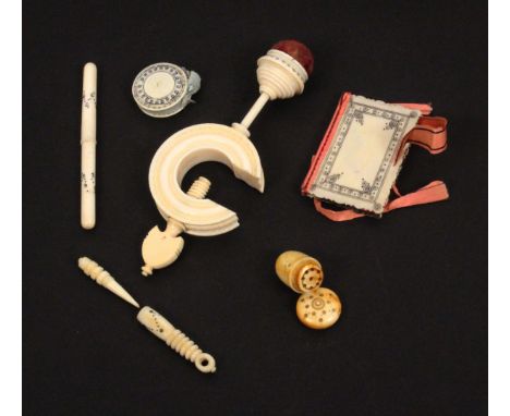 Six 19th Century ivory Madras sewing tools with burnt circle decoration, comprising a pin cushion clamp with ‘C’ form frame, 