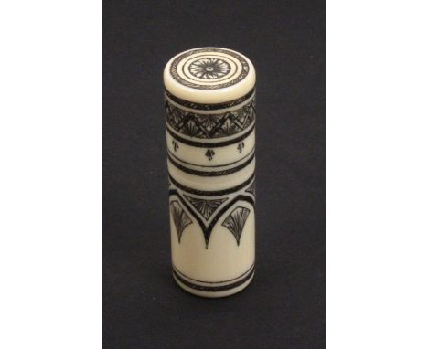 A 19th Century Anglo Indian ivory sewing companion, of cylinder form with engraved black lac decoration with internal gilt me