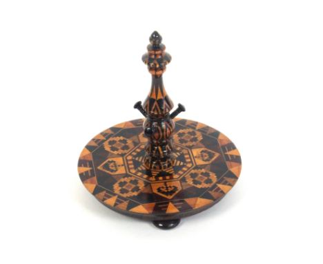 An attractive Tunbridge ware rosewood ring stand, the circular base on three turned feet and decorated in geometric mosaic an