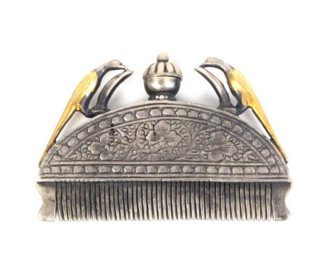 A 19th Century silver and gilt ethnic comb, the floral engraved arched mount below a lidded vase and flanked by part gilded b