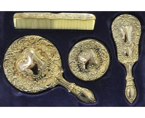 A silver plated boxed dressing table set, embossed with flowers and scrolling foliage, comprising of a hand mirror, hairbrush