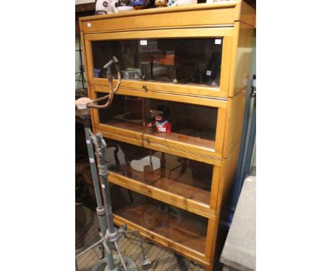 A Globe Wernicke style four graduating shelf book case in light oak 87cm wide x 31cm deep x 151cm high. Condition good  