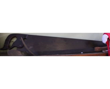 A vintage two-handled saw and two Bush Whackers