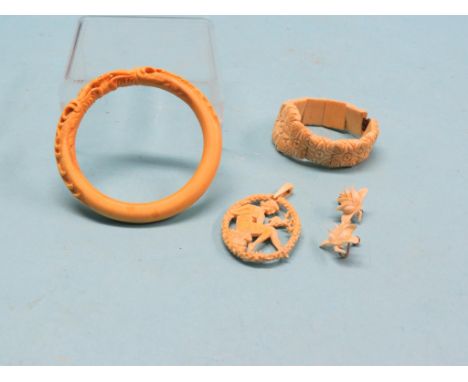 A Victorian carved ivory pendant, oval seated girl, a carved ivory bangle, pair of bone ear-rings and an expanding carved bon