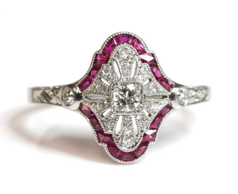 An American Art Deco-style ruby and diamond plaque ring,with a brilliant cut diamond, milligrain set to the centre. An ogee s