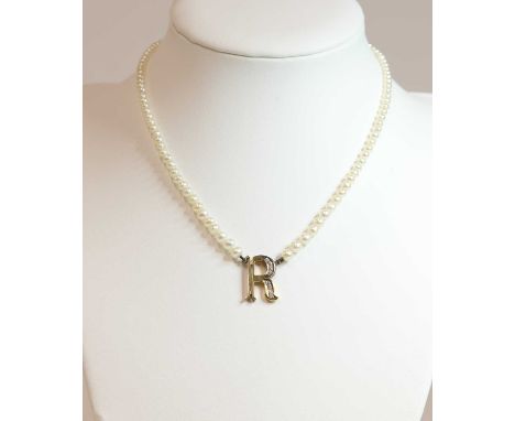 A single row pearl and diamond initial necklace,with a pierced Perpetua Roman initial 'R' grain set with a row of graduated b